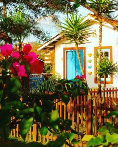 拉夫拉斯诺瓦斯Vila das Artes Chales的一座带木栅栏和一些鲜花的房子