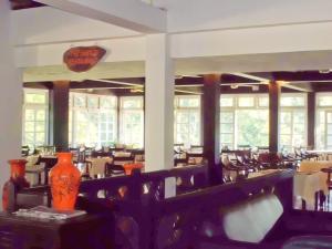 基图尔格勒Kithulgala Rest House的用餐室设有桌椅和窗户。