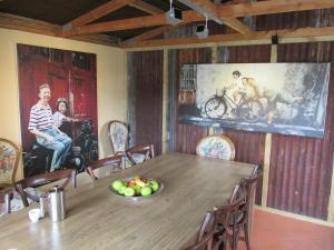 基督城设计师小屋的用餐室配有木桌和墙上的绘画作品