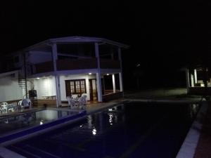 比亚维森西奥Finca Campestre El Encanto的一座晚上设有游泳池的房子