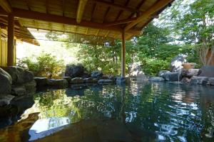 水上町辰巳馆酒店的一座带岩石的庭院里的水池