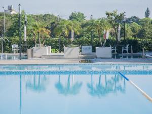 Wuri清新温泉饭店的一座拥有蓝色海水和棕榈树的游泳池