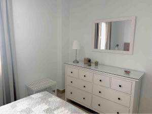 阿尔科斯-德拉弗龙特拉Apartamento Felisa的白色卧室配有梳妆台和镜子