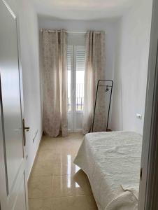 阿尔科斯-德拉弗龙特拉Apartamento Felisa的白色的卧室设有床和窗户
