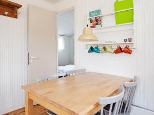 瓦伊厄斯斯特兰德4 person holiday home in Vejers Strand的一间带木桌和椅子的用餐室