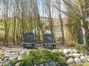 Remmer StrandThree-Bedroom Holiday home in Struer 5的花园庭院的两把椅子