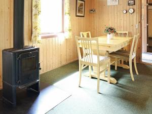 Sønder NissumTwo-Bedroom Holiday home in Ulfborg 4的一间带桌子和炉灶的用餐室