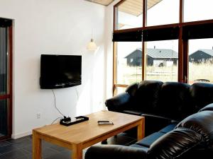 托斯明德8 person holiday home in Ulfborg的带沙发、桌子和电视的客厅