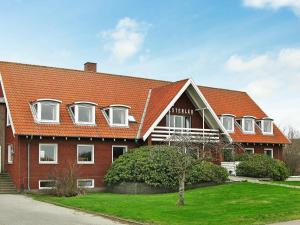 SindrupFourteen-Bedroom Holiday home in Hurup Thy的红砖建筑,有白色的窗户和屋顶