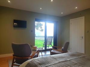 布里斯托Open acres accommodation and airport parking的一间卧室配有床、椅子和窗户