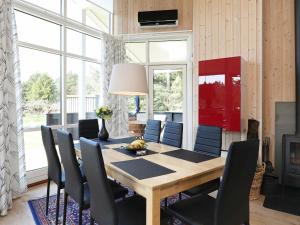 法贾德嘉德8 person holiday home in Ulfborg的一间带木桌和椅子的用餐室