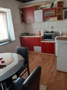 奥赫里德Apartment NIKOLA ORANGE的厨房配有红色橱柜和桌椅