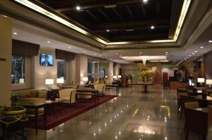 马斯喀特苎麻集团盖斯特林酒店的大堂,设有桌椅