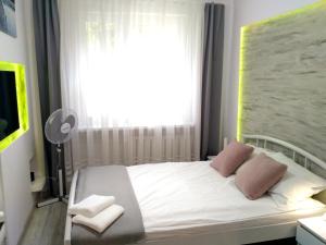 吉日茨科Apartament UnoPuro w centrum Giżycka的卧室配有白色的床、两个枕头和窗户