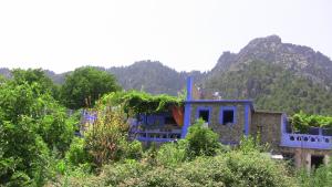 IzilaneGîte de montagne Azilane的蓝色房子,背景是山