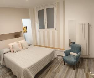蒙雷亚莱Casa Margò的一间卧室配有一张床和一张蓝色椅子