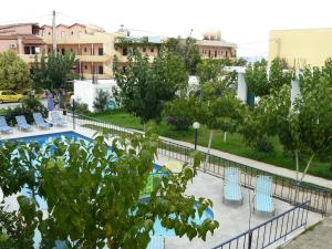 耶奥伊乌波利斯Leonidas Studios & Apartments的享有带蓝椅和树木的游泳池的景致