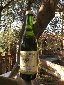 滨海圣西尔GuestHouse Du Moulin (logement neuf)的一瓶葡萄酒坐在树旁