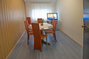 马里博尔M旅舍的一间带桌椅和电视的用餐室