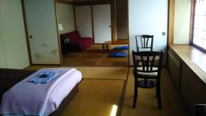 白马村Sakka Sanso山林小屋的一间设有床铺和两把椅子的房间