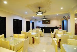 丹戎槟榔全景酒店的用餐室配有白色的桌子和黄色的椅子