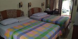 玛琅艾尼之家旅馆的一间卧室设有两张床和窗户。