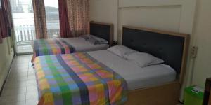 玛琅艾尼之家旅馆的一间卧室设有两张床和窗户。