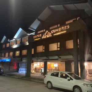 科伊艾科Entre Cumbres Hotel & Apart Hotel的停在大楼前的白色汽车