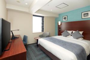 横滨MYSTAYS 横滨酒店的酒店客房配有一张床、一张书桌和一台电视。