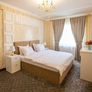 纳曼干ORZU HOTEL的一间卧室配有一张大床和一个吊灯。