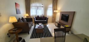 阿布扎比象牙酒店公寓的带沙发的客厅和带电视的客厅