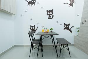 努沙再也Ezzyhome@Medini的一间用餐室,墙上挂着桌子和黑猫