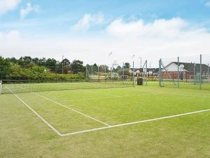 罗莫柯克比4 person holiday home in R m的网球场,上面有两顶网球网