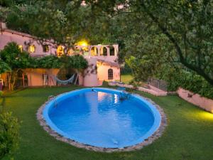 里卡迪Belvilla by OYO Mandorlo的一座房子的院子中的一个大型蓝色游泳池