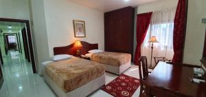 阿布扎比象牙酒店公寓的一间酒店客房内设有两张床的房间