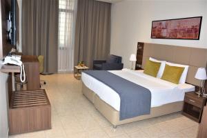 吉布提Capital Hotel Djibouti的配有一张大床和一部电话的酒店客房