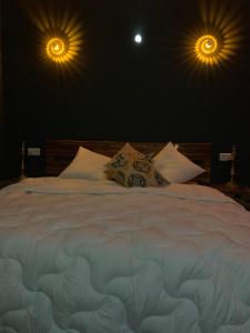 鲁贝Diane Luxury 1的卧室配有一张带两个灯的大白色床
