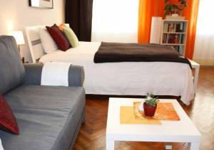 维也纳Cosy Appartement close to City的一间卧室配有一张床、一张沙发和一张桌子