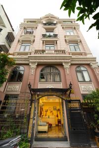 胡志明市Maison Royale的一座大型粉红色建筑,设有开放式门