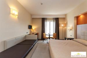 阿尔贝罗贝洛奥林波格兰德酒店的配有一张床和一张书桌的酒店客房