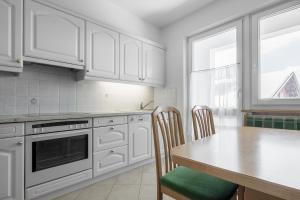 塞尔瓦迪加尔代纳山谷ARTEFUGIUM panoramico的厨房配有白色橱柜和桌椅
