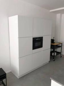 马斯特里赫特Huize Hoge Fronten的厨房配有白色橱柜和黑烤箱。