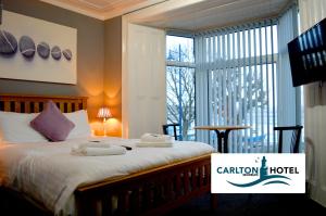 马伯斯曼博斯卡尔顿酒店的一间卧室配有带毛巾的床