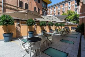 罗马Albergo Etico Roma的一个带桌椅和遮阳伞的户外庭院。
