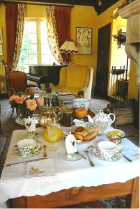 维尔法格Le Petit Manoir des Bruyères的客厅里一张桌子,上面有食物和钢琴