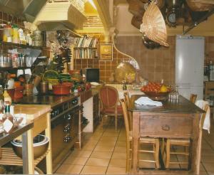 维尔法格Le Petit Manoir des Bruyères的厨房配有炉灶和桌子。