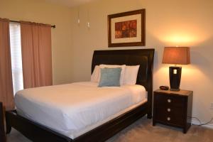 休斯顿The Reside Fully Furnished Condos - Medical Stays Welcome的一间卧室,配有一张床和床头灯