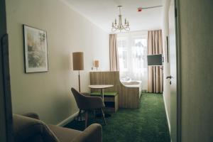 奎德林堡阿德尔海德加尼酒店的客厅配有桌子和椅子