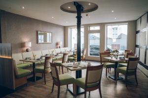 奎德林堡阿德尔海德加尼酒店的用餐室设有桌椅和窗户。