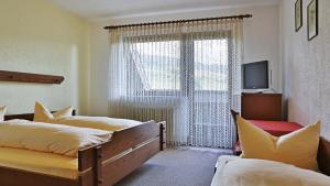 策尔阿姆哈尔梅尔斯巴赫格努讷霍夫酒店的一间卧室设有两张床和窗户。
